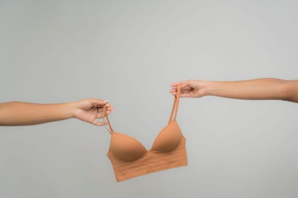 Nude adhesive sticky bra held against a neutral background