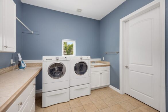 Clean modern laundry room with washing appliances