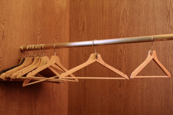 Row of wooden hangers in a minimalist closet