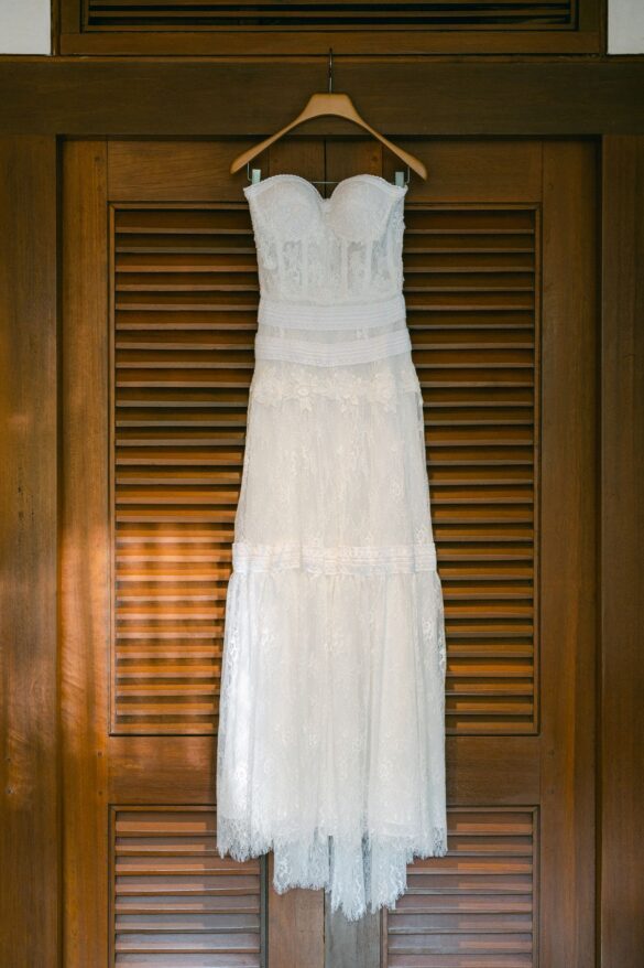 White wedding dress hanging gracefully on a wooden hanger
